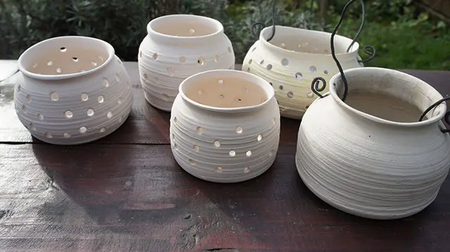 White pots with holes on a garden table